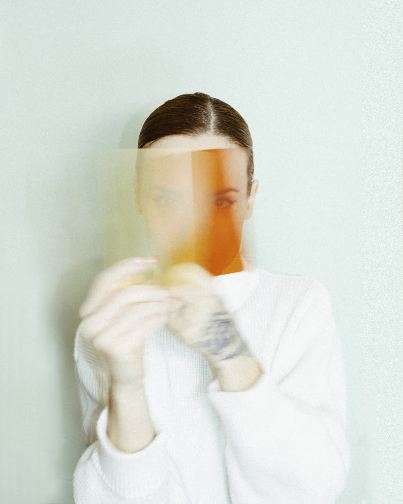 Artistic portrait of a woman with blurred motion and orange overlay for a surreal effect.